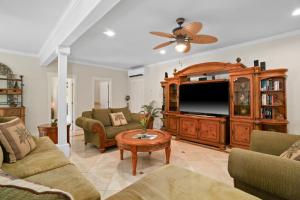 a living room with a large entertainment center and a flat screen tv at Princeville/Hanalei Lux 4BR 3.5Ba w/AC+CAR in Princeville