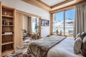 ein Schlafzimmer mit einem Bett und einem großen Fenster in der Unterkunft Hotel Annapurna in Courchevel + 168 Fotos