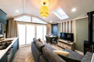 a living room with a couch and a tv at Landal Bryn Morfydd in Llanrhaiadr