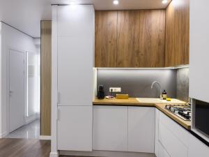 a kitchen with white cabinets and a sink at Central City Vibes Apartment in Chişinău