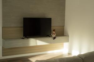 a teddy bear sitting on a tv stand in a living room at Central City Vibes Apartment in Chişinău