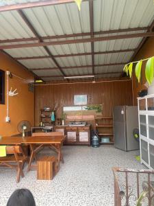 een woonkamer met een tafel en een koelkast bij Stay here at pai in Pai