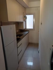 a small kitchen with a refrigerator and a window at Monoambiente centrico in Santiago del Estero