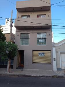 a building with a garage door with a sign on it at Monoambiente centrico in Santiago del Estero