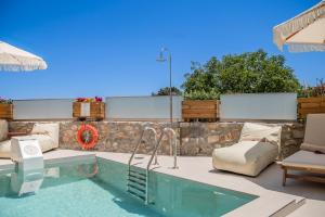 ein Pool mit einem Stuhl und einem Tisch neben einer Terrasse in der Unterkunft Casa Karinea - Serene Stone House Retreat in Áyios Vasílios