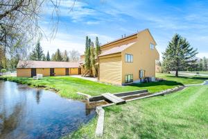 a house with a river in front of it at Trout Creek Condo Resort: Condo 78 in Conway