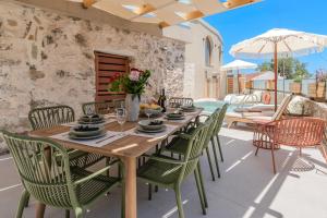 a wooden table and chairs on a patio at Casa Karinea - Serene Stone House Retreat in Áyios Vasílios
