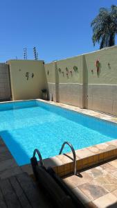 カウカイアにあるCondomínio tropicalienteの建物の前に椅子2脚付きのスイミングプール