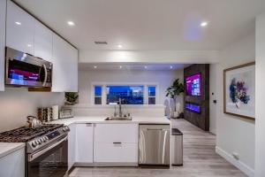 une cuisine blanche avec un évier et une cuisinière dans l'établissement Lux Escape 2: Views Spa Games Safari Tent Golf, à San Diego