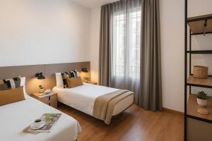 ein Hotelzimmer mit zwei Betten und einem Fenster in der Unterkunft The Corner Apartments by Aspasios in Barcelona