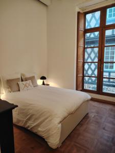 勒芒Majestueux Bouquet的一间带大床和窗户的白色卧室