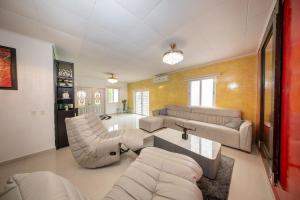 een woonkamer met een bank, stoelen en een tafel bij Villa Laura, Central Spacious Oasis with Private Pool in Willemstad