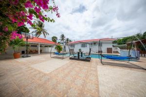 een grote binnenplaats met schommels en een zwembad bij Villa Laura, Central Spacious Oasis with Private Pool in Willemstad