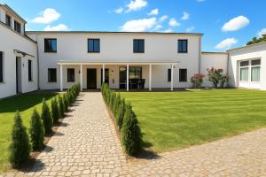 una grande casa bianca con un prato verde di Airport-Messe Apartments a Dusseldorf