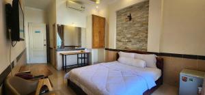 a bedroom with a bed in a room with a table at Ngoc Son Hotel in Bien Hoa