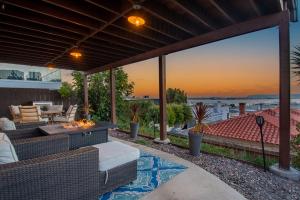 d'une terrasse avec un canapé et un foyer extérieur. dans l'établissement Hilltop Hacienda – Private Villa Panoramic Views, à San Diego