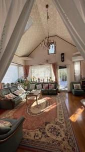 a large living room with couches and a rug at ペンションあけまの森 in Daisen