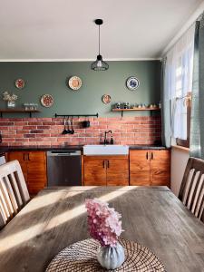 GałkowoPrzystanek Gałkowo的厨房配有带花瓶的木桌