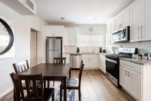 a kitchen with white cabinets and a table and chairs at Entire Home, 7 Minutes from Phoenix Airport in Phoenix