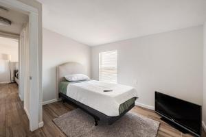 a bedroom with a bed and a flat screen tv at Entire Home, 7 Minutes from Phoenix Airport in Phoenix