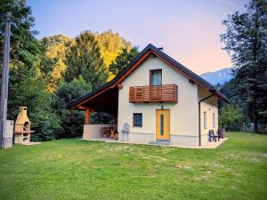 ein kleines weißes Haus mit einem Holzdach in der Unterkunft Krtajse in Slap ob Idrijci