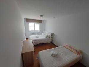ein kleines Zimmer mit zwei Betten und einem Fenster in der Unterkunft Excelente piso de 3 habitaciones dobles, 2 baños y terraza 30 mts in Narón