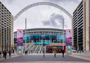 a stadium with a red double decker bus in front of it at Wembley Park prime location for Stadium events City break in London