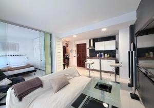 um quarto com uma cama branca e uma cozinha em Bonito Apartamento en Moraira a 5 min de la Playa em Moraira