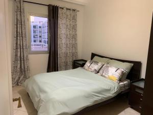 una camera da letto con un letto bianco con una finestra di Cosy 2 bedroom appartment a La Corniche 1 altra foto