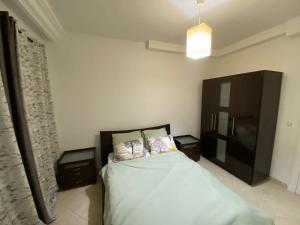 una camera da letto con un letto grande con due comodini di Cosy 2 bedroom appartment a La Corniche