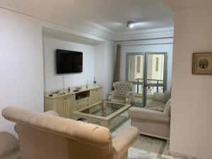 un soggiorno con un divano e una TV di Cosy 2 bedroom appartment a La Corniche