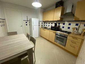 una cucina con un tavolo e un frigorifero bianco di Cosy 2 bedroom appartment a La Corniche