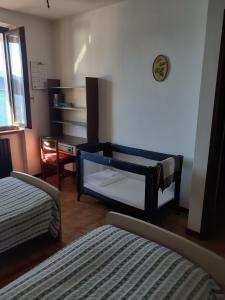 a bedroom with two beds and a table and a desk at CASA IN RIVA AL LAGO in Varenna