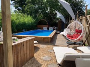 a patio with a pool and chairs and an umbrella at Pause Thermale Chambre avec Spa in Herstal