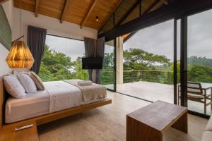 a bedroom with a bed and a balcony at Villa Bahia Oceanview Designer Retreat Malpais in Mal País