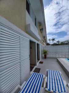 zwei blau-weiße Stühle auf dem Balkon eines Hauses in der Unterkunft Sobrado aconchegante com Piscina Ar Condicionado 3 quartos a 150 metros do mar no Brejatuba in Guaratuba