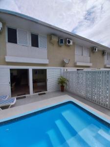 ein Swimmingpool vor einem Haus in der Unterkunft Sobrado aconchegante com Piscina Ar Condicionado 3 quartos a 150 metros do mar no Brejatuba in Guaratuba