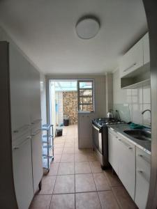 a kitchen with white cabinets and a tile floor at Sobrado aconchegante com Piscina Ar Condicionado 3 quartos a 150 metros do mar no Brejatuba in Guaratuba