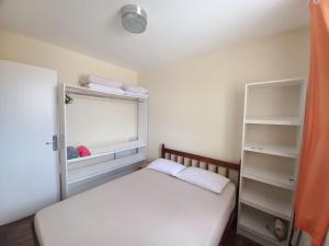 ein kleines Schlafzimmer mit einem Bett und einem Fenster in der Unterkunft Sobrado aconchegante com Piscina Ar Condicionado 3 quartos a 150 metros do mar no Brejatuba in Guaratuba + 111 Fotos