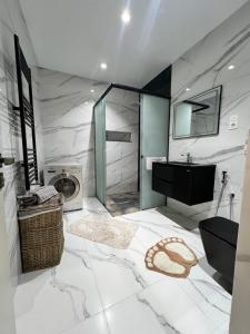 a bathroom with a sink and a washing machine at maisoncarnot in El Biar