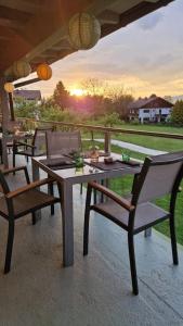 a table and chairs with the sunset in the background at die Hauswirtschaft in Maria Elend
