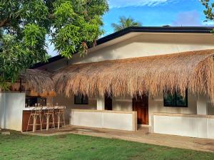 a house with a straw roof and stools in front of it at Villa Aniani in El Nido