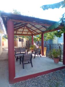 a group of benches sitting under a pavilion at Mi refugio 2 in San Fernando de Monte Cristi