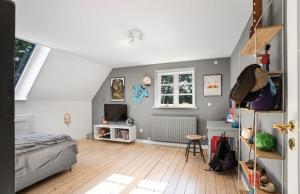 ein Schlafzimmer mit einem Bett und einem Fernseher in einem Zimmer in der Unterkunft Large Holiday Home With Pool On South Lolland Coast in Dannemare