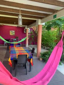 un patio con tavolo e amache di Hostal Casaluna San Andres a San Andrés