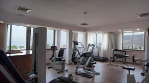 un gimnasio con cintas de correr y bicicletas estáticas en una sala con ventanas en Kinorot Hotel, en Tiberíades