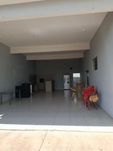 a living room with red chairs and a white tile floor at Área de lazer in Assis