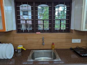 a sink in a kitchen with a window above it at Sankeerthanam - Lounge in serenity in Cochin