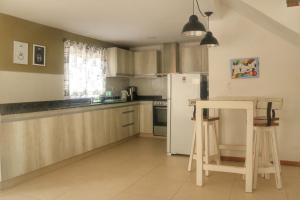 a kitchen with wooden cabinets and a white refrigerator at Quiya ná in Cortaderas