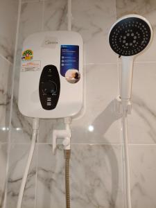 ein Handy-Ladegerät in einem Badezimmer mit Dusche in der Unterkunft D45 Home - BTS Ratchathewi N1 Station in Ban Nong Chaeng